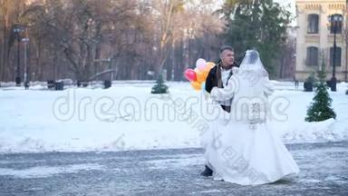 冬季婚礼。 新婚夫妇穿着婚纱，在一个白雪皑皑的公园里，与一个